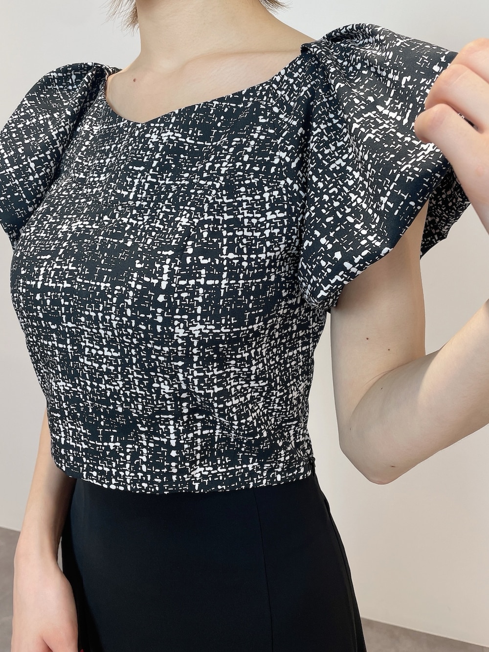 ブラック系のシャツ/ブラウス、ホワイト系のハンドバッグ、ブラック系のパンプスを着用したレディースの春コーディネートの7枚目の写真