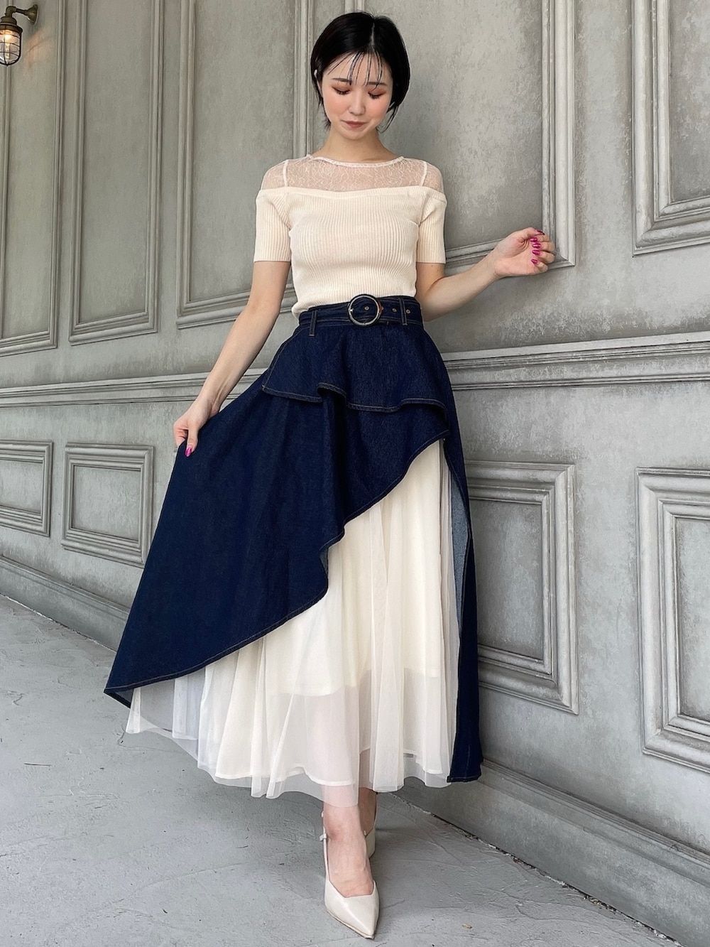 ブルー系のスカート、ホワイト系のニット/セーター、ベージュ系のサンダルを着用したレディースの夏コーディネートの2枚目の写真