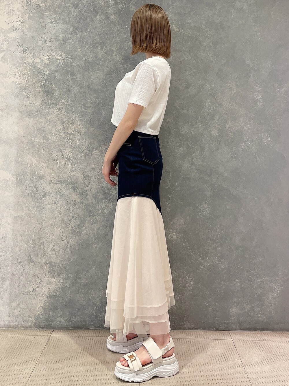 ホワイト系のカーディガン/ボレロ、ブルー系のスカート、ホワイト系のサンダルを着用したレディースの春コーディネートの2枚目の写真