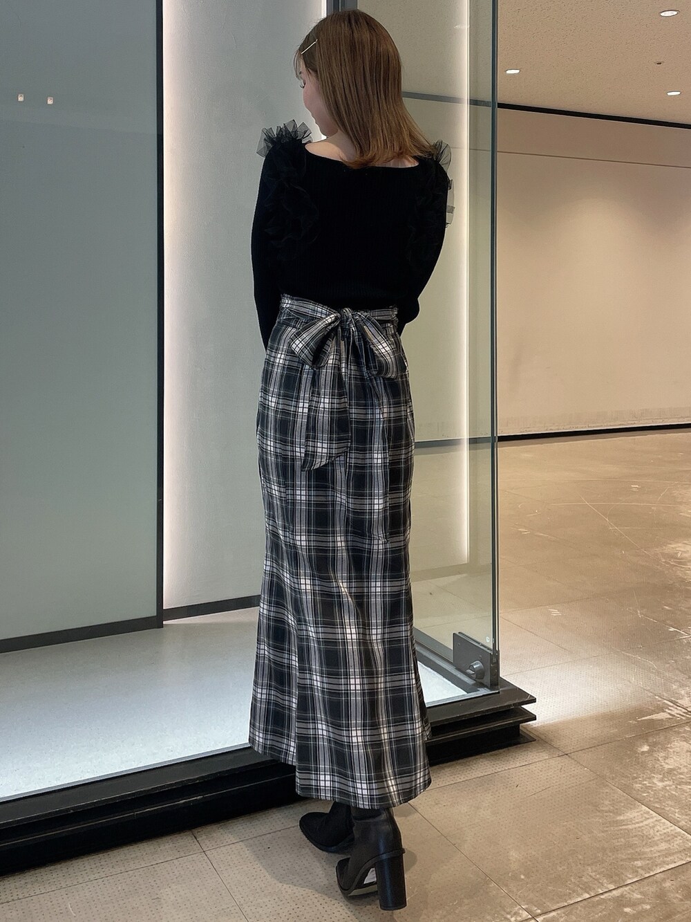 ブラック系のニット/セーター、その他のスカート、ブラック系のブーツを着用したレディースの冬コーディネートの4枚目の写真