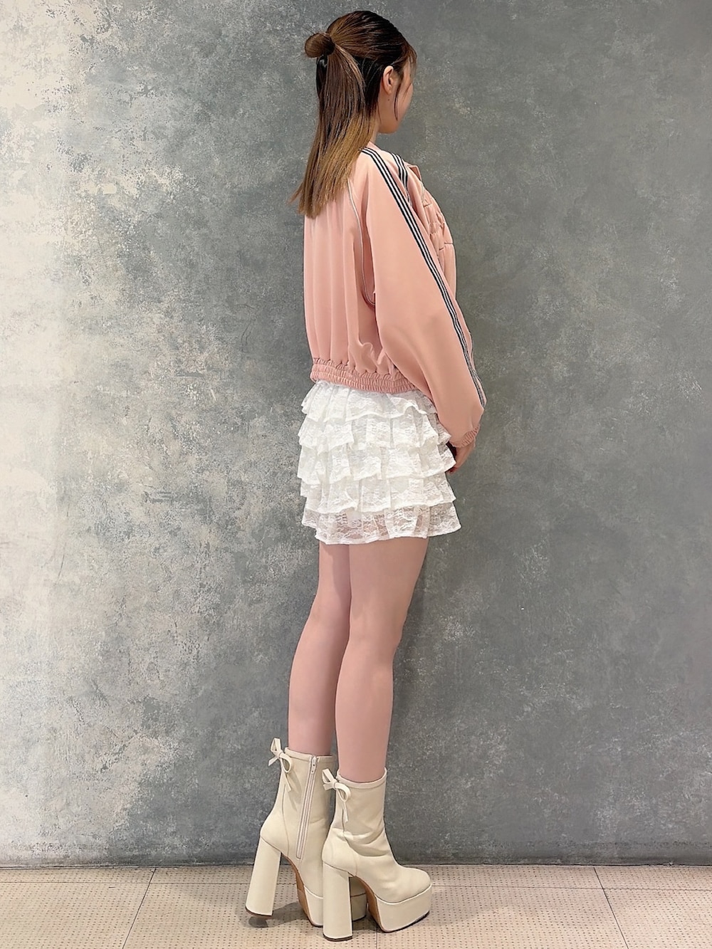 ピンク系のその他アウター、ホワイト系のスカート、ホワイト系のニット/セーターを着用したレディースの冬コーディネートの3枚目の写真