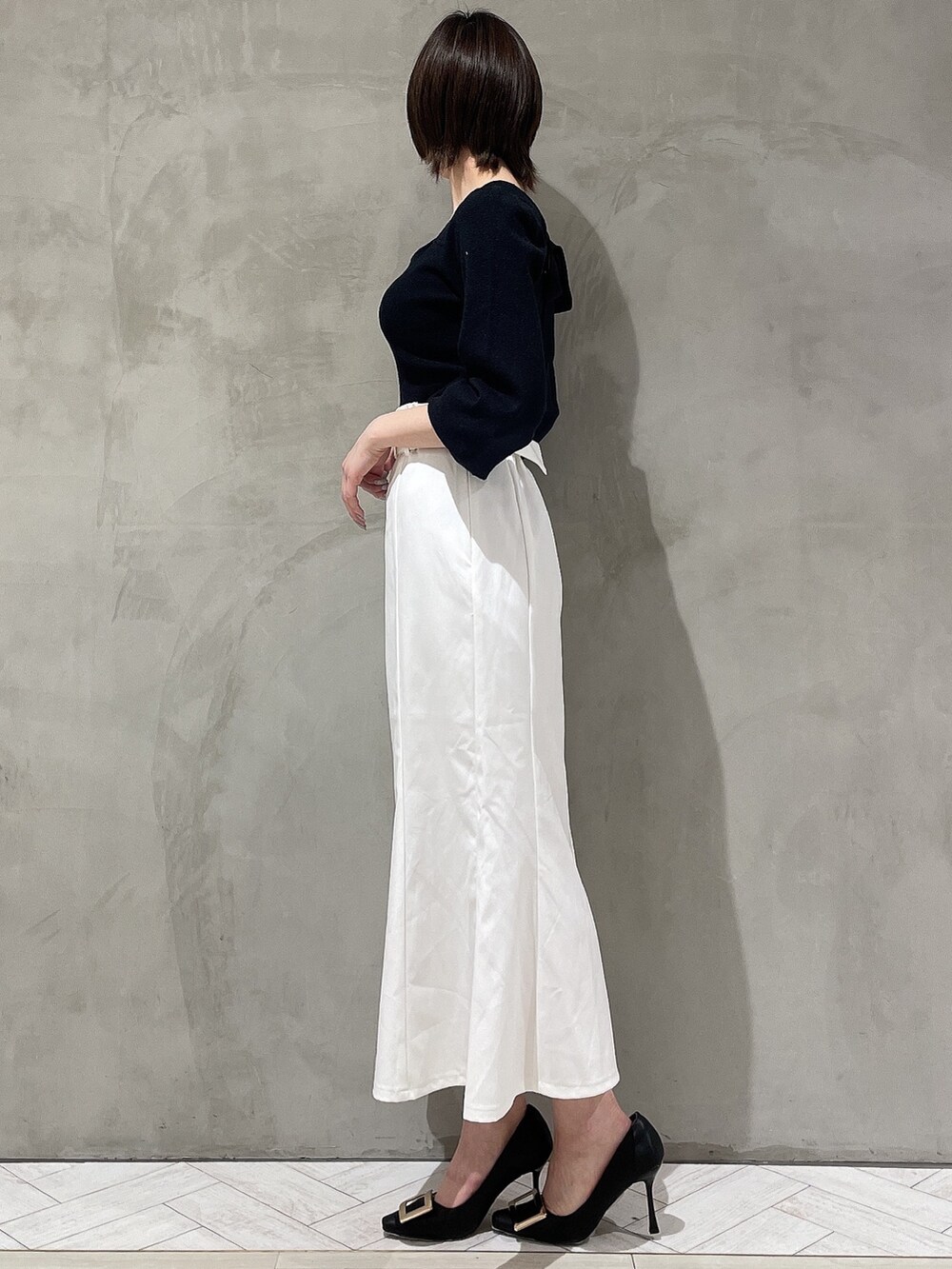 ブラック系のパンプス、ブラック系のニット/セーター、ホワイト系のデニムジャケットを着用したレディースの冬コーディネートの6枚目の写真