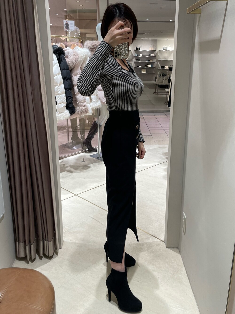 その他のニット/セーター、ブラック系のスカート、ブラック系のブーツを着用したレディースの冬コーディネートの4枚目の写真