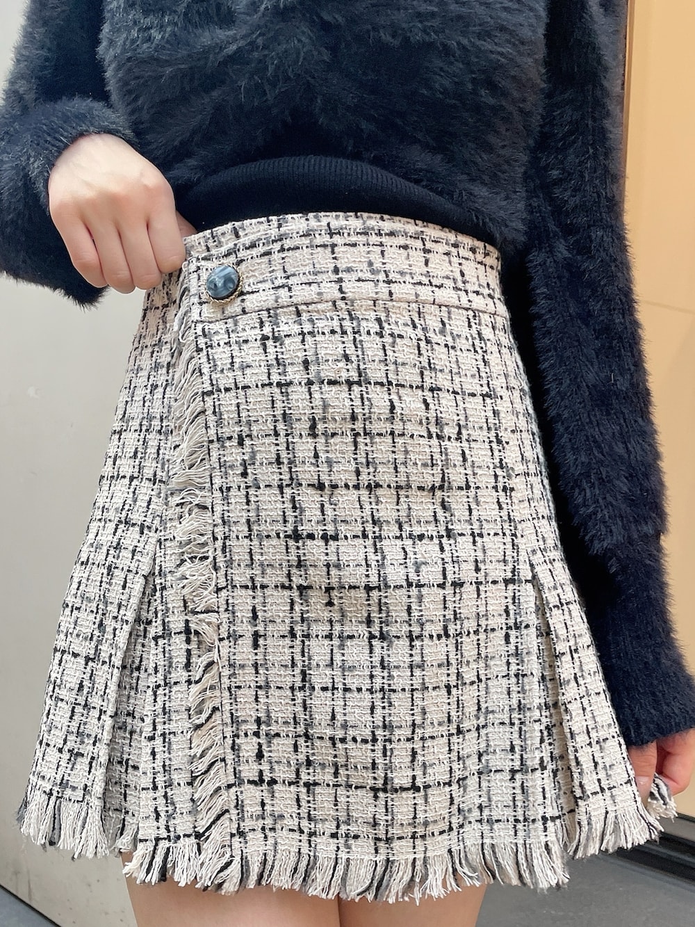 ブラック系のブーツ、ホワイト系のスカート、ブラック系のニット/セーターを着用したレディースの秋コーディネートの5枚目の写真