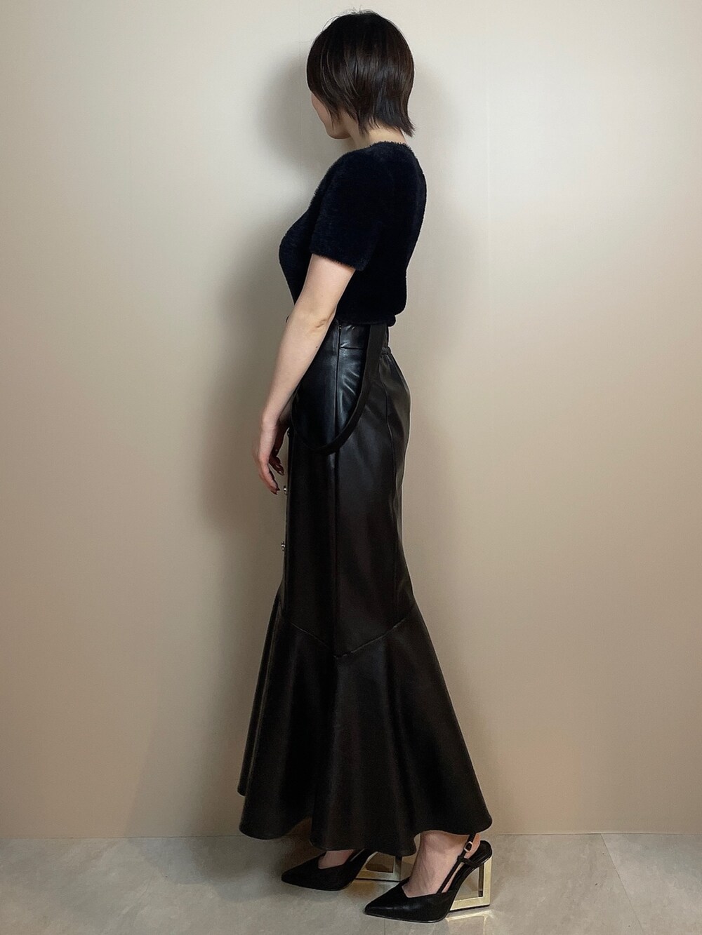 ブラック系のニット/セーター、ブラック系のスカート、ブラック系のサンダルを着用したレディースの夏コーディネートの3枚目の写真