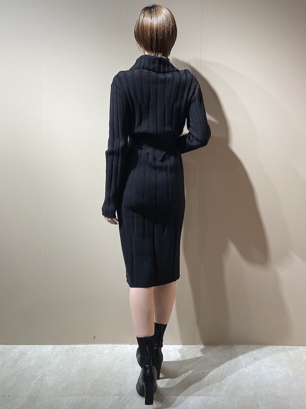 ブラック系のブーツ、ブラック系のワンピースを着用したレディースの秋コーディネートの4枚目の写真