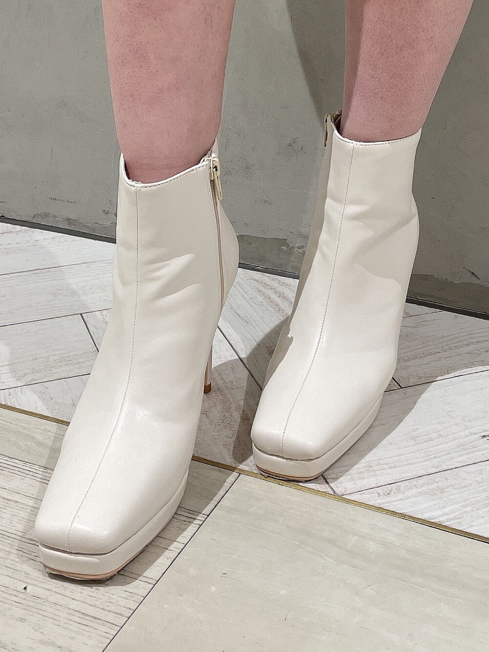 ブラウン系のハンドバッグ、ホワイト系のブーツ、グレー系のシャツワンピースを着用したレディースの冬コーディネートの7枚目の写真