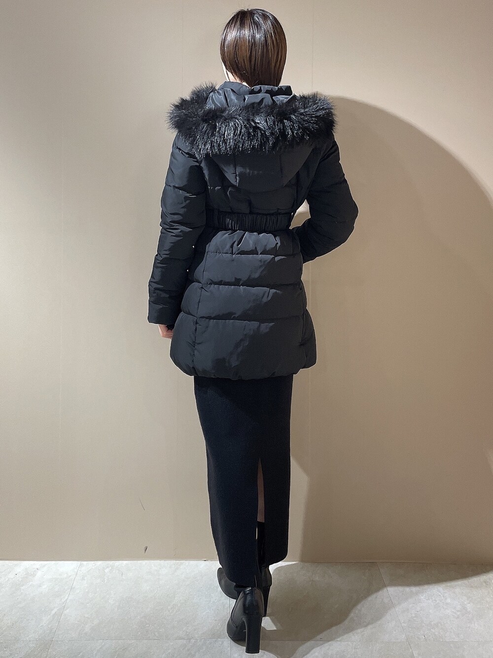 ブラック系のダウンジャケット/コート、ブラック系のワンピース、ブラック系のブーツを着用したレディースの秋コーディネートの3枚目の写真