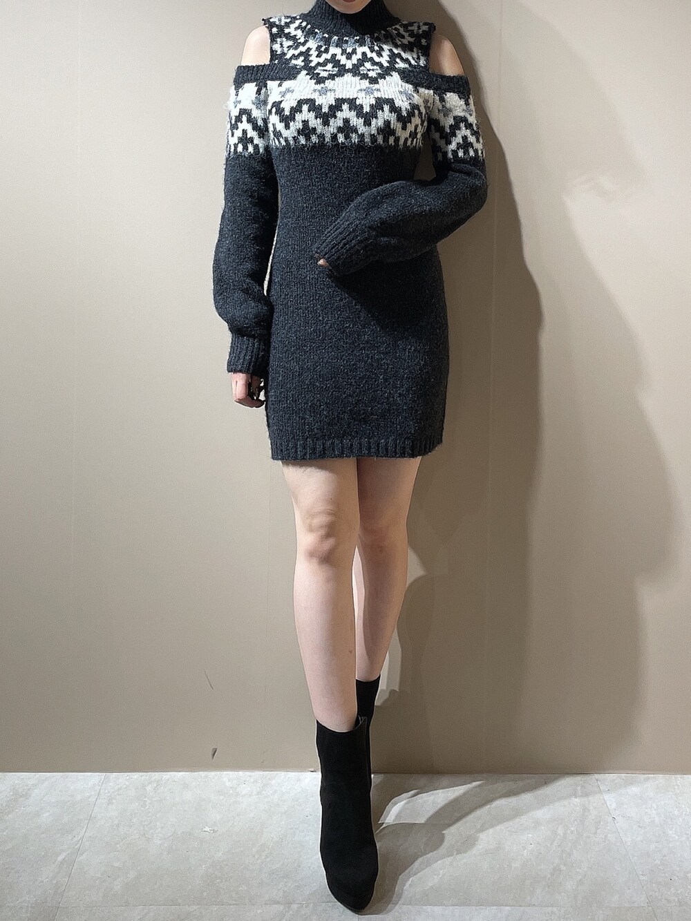 グレー系のワンピース、ブラック系のブーツを着用したレディースの秋コーディネートの2枚目の写真