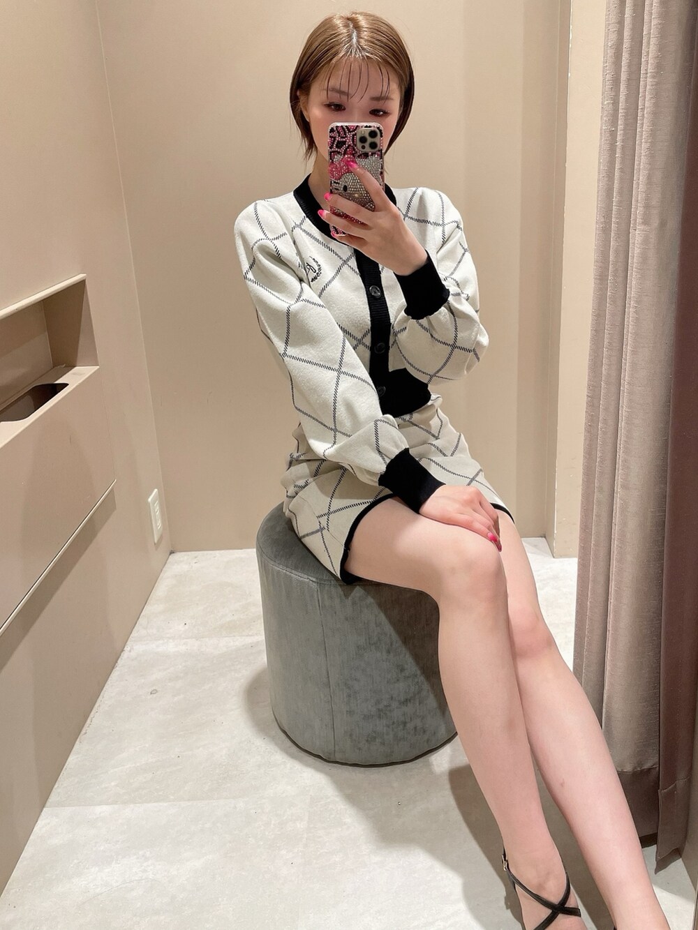 ホワイト系のカーディガン/ボレロ、ホワイト系のスカート、ブラック系のパンプスを着用したレディースの冬コーディネートの2枚目の写真