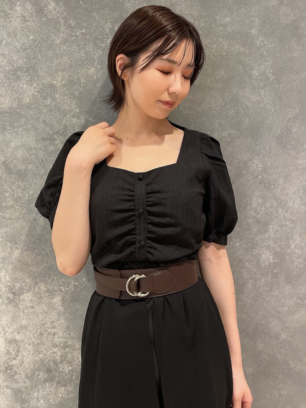 ブラック系のワンピース、ブラック系のサンダル、ブラウン系のベルトを着用したレディースの夏コーディネートの5枚目の写真