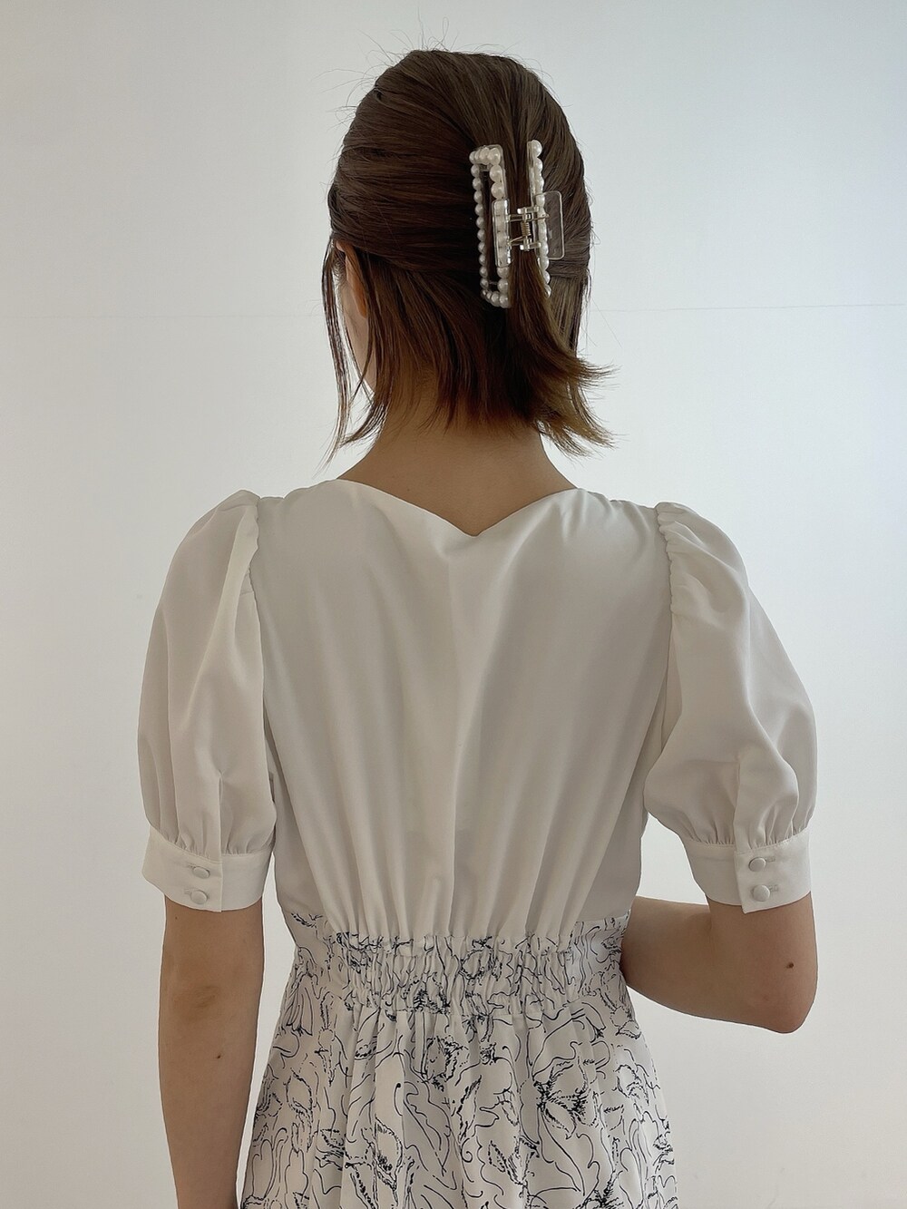 ホワイト系のワンピース、ホワイト系のハンドバッグ、ホワイト系のパンプスを着用したレディースの春コーディネートの7枚目の写真