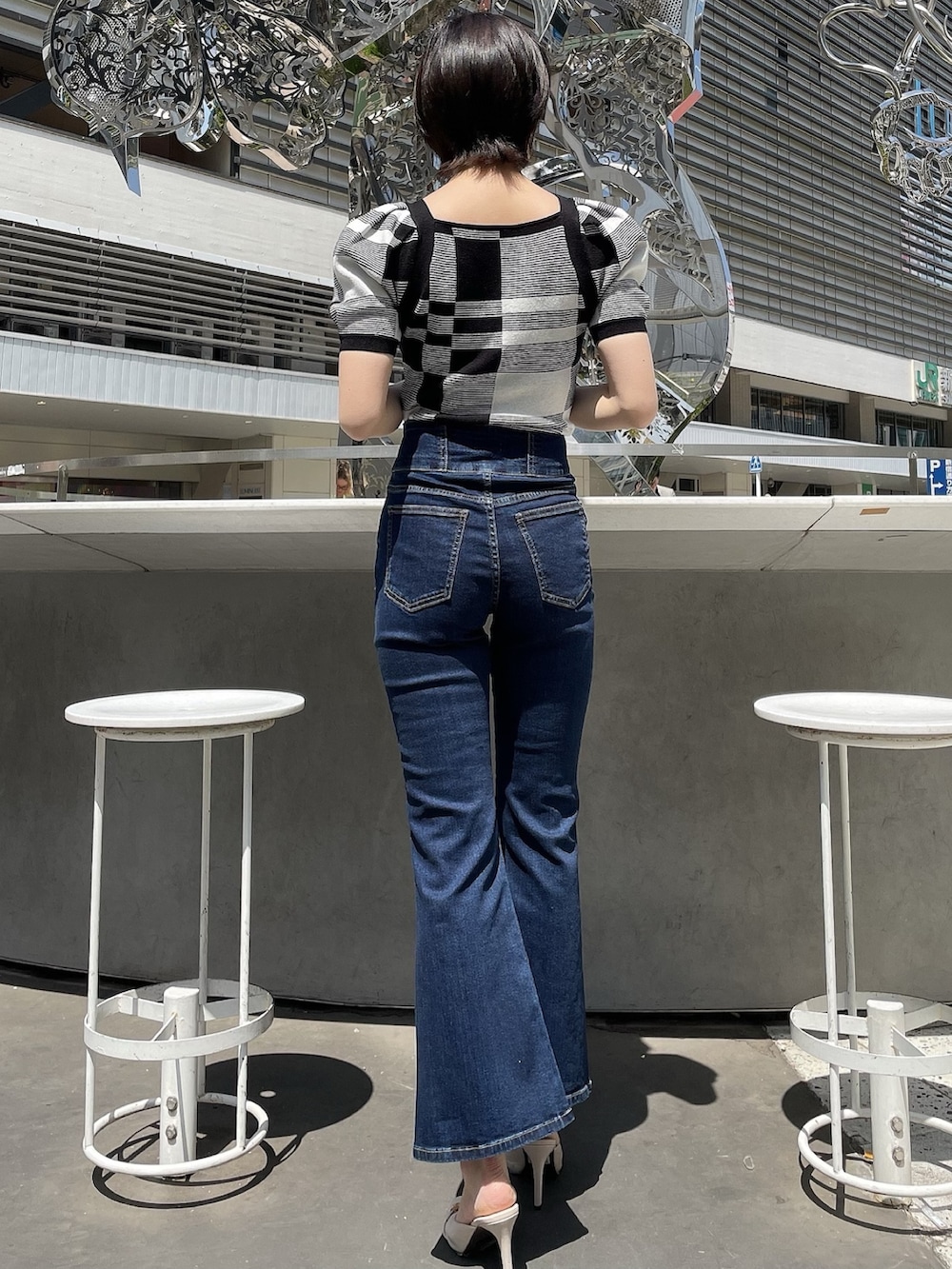 その他のニット/セーター、ホワイト系のサンダル、ブルー系のデニムパンツを着用したレディースの春コーディネートの3枚目の写真