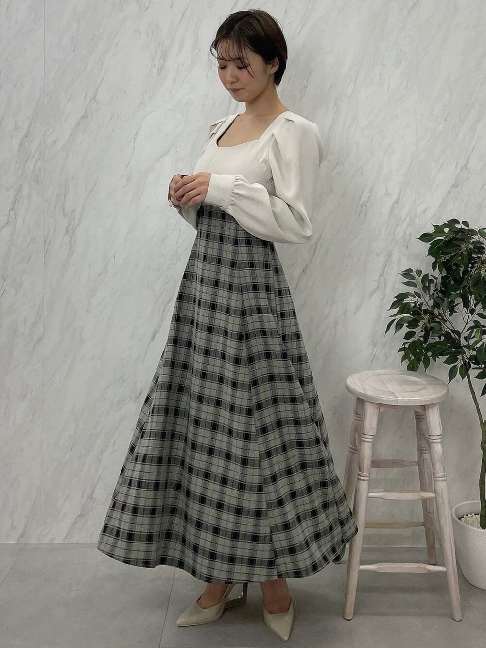 ベージュ系のサンダル、グレー系のテーラードジャケット、ホワイト系のワンピースを着用したレディースの秋コーディネートの4枚目の写真