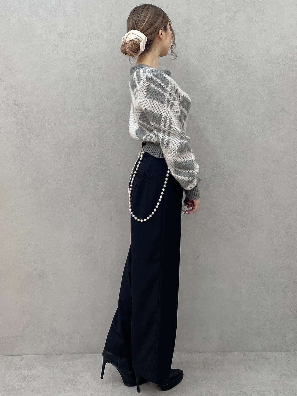 グレー系のニット/セーター、ブラック系のその他パンツ、ブラック系のブーツを着用したレディースの秋コーディネートの5枚目の写真