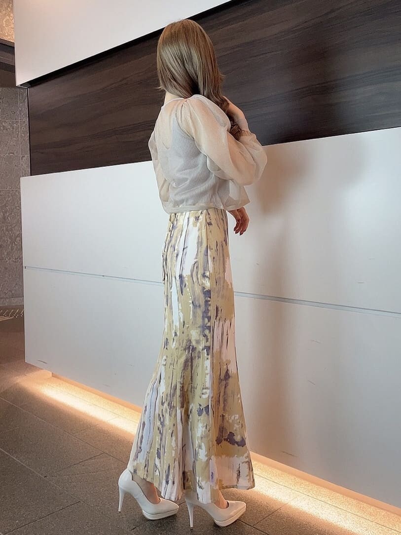 ベージュ系のライダースジャケット、パープル系のスカート、ホワイト系のパンプスを着用したレディースの冬コーディネートの6枚目の写真