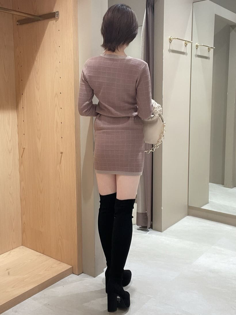 ブラック系のブーツ、ベージュ系のワンピース、ホワイト系のハンドバッグを着用したレディースの秋コーディネートの3枚目の写真