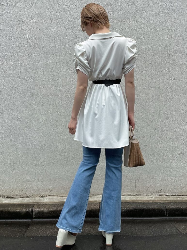 ホワイト系のサンダル、ベージュ系のハンドバッグ、ブルー系のデニムパンツを着用したレディースの夏コーディネートの3枚目の写真