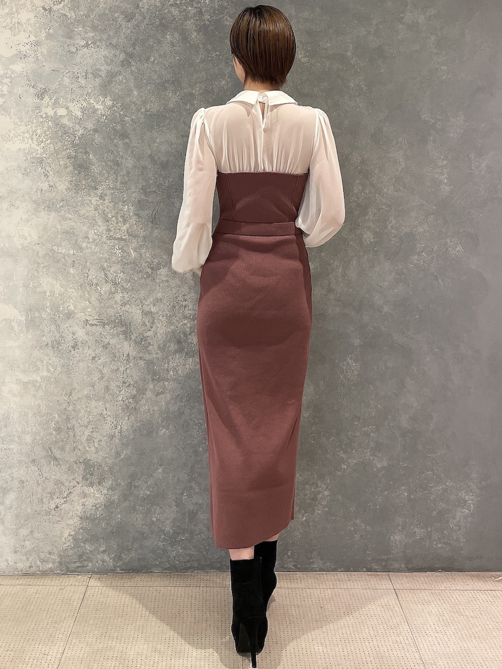 ブラック系のブーツ、ホワイト系のブルゾン、ブラウン系のワンピースを着用したレディースの秋コーディネートの7枚目の写真