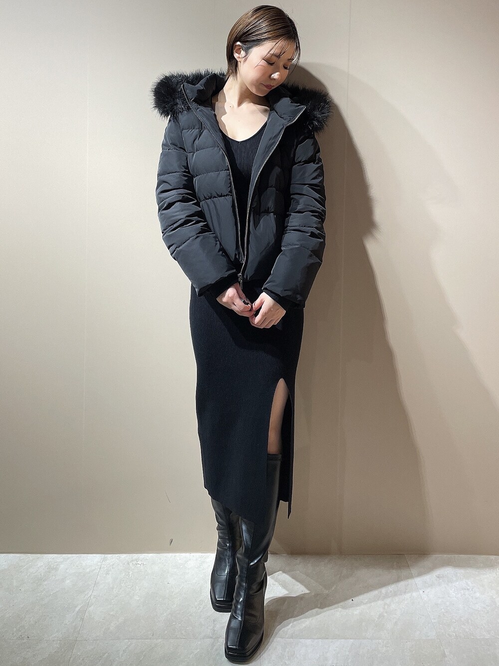 ブラック系のワンピース、ブラック系のダウンジャケット/コート、ブラック系のブーツを着用したレディースの秋コーディネートの4枚目の写真