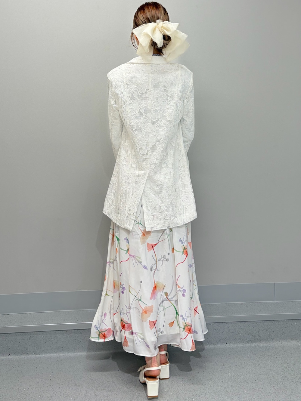 ホワイト系のテーラードジャケット、パープル系のニット/セーター、ホワイト系のスカートを着用したレディースの冬コーディネートの4枚目の写真