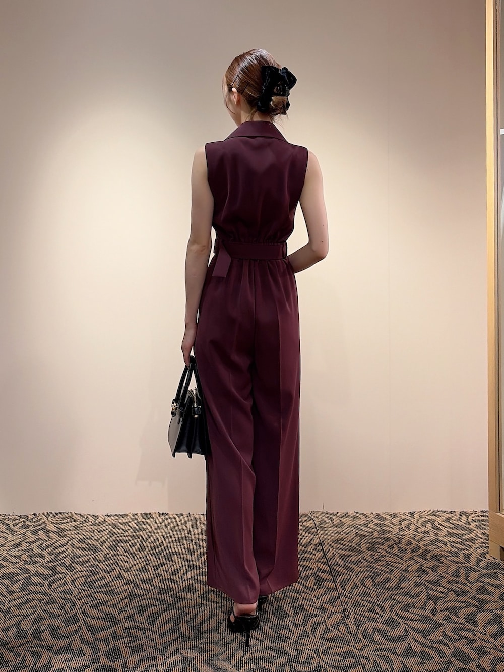 レッド系のワンピース、ブラック系のハンドバッグ、ブラック系のバレッタ/ヘアクリップを着用したレディースの夏コーディネートの3枚目の写真