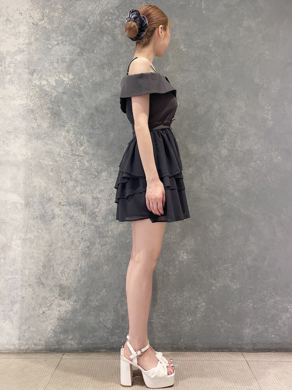 グレー系のワンピース、ホワイト系のサンダル、グレー系のシュシュを着用したレディースの夏コーディネートの5枚目の写真