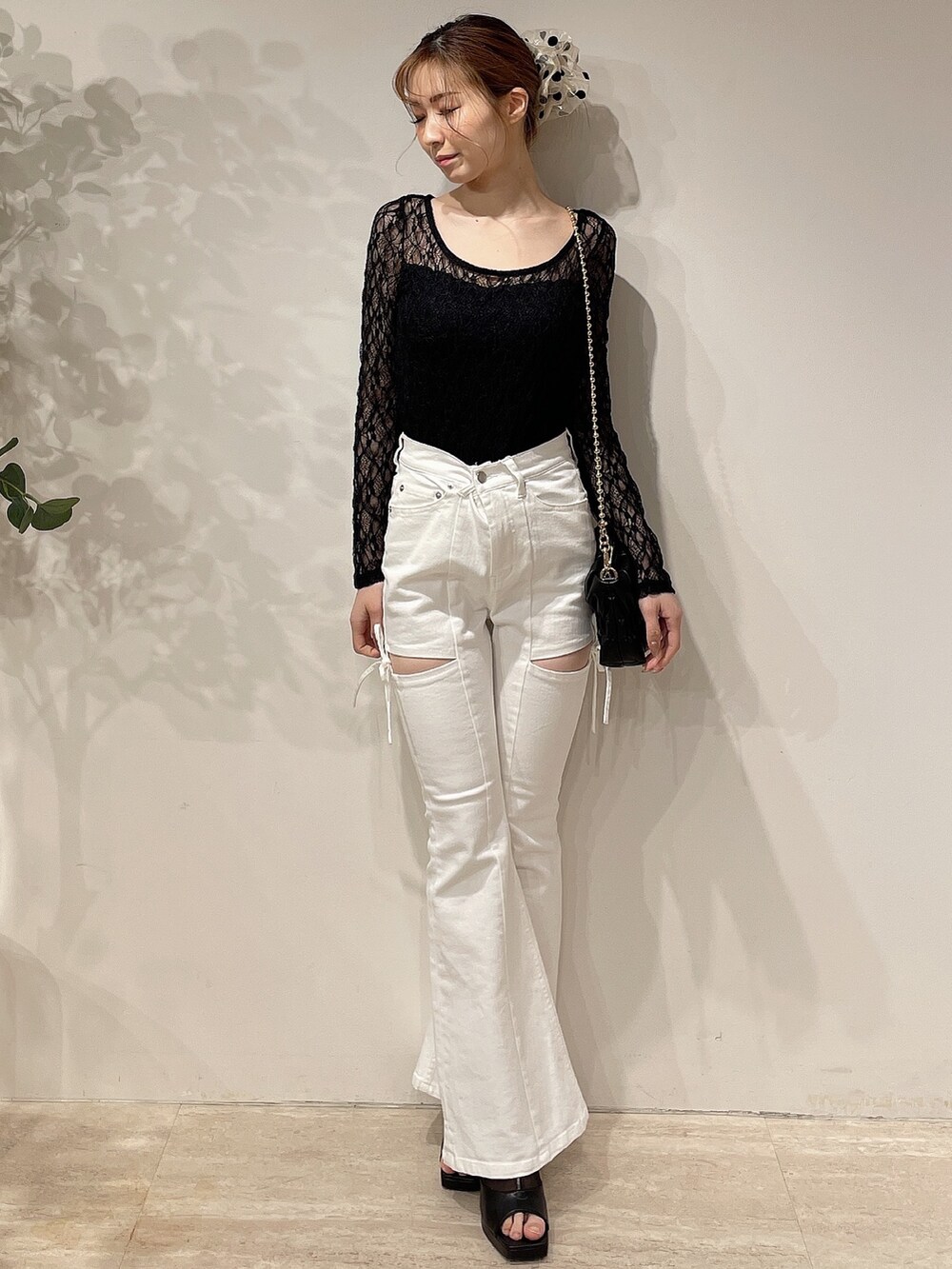 ブラック系のライダースジャケット、ホワイト系のデニムパンツ、ブラック系のブーツを着用したレディースの春コーディネートの5枚目の写真