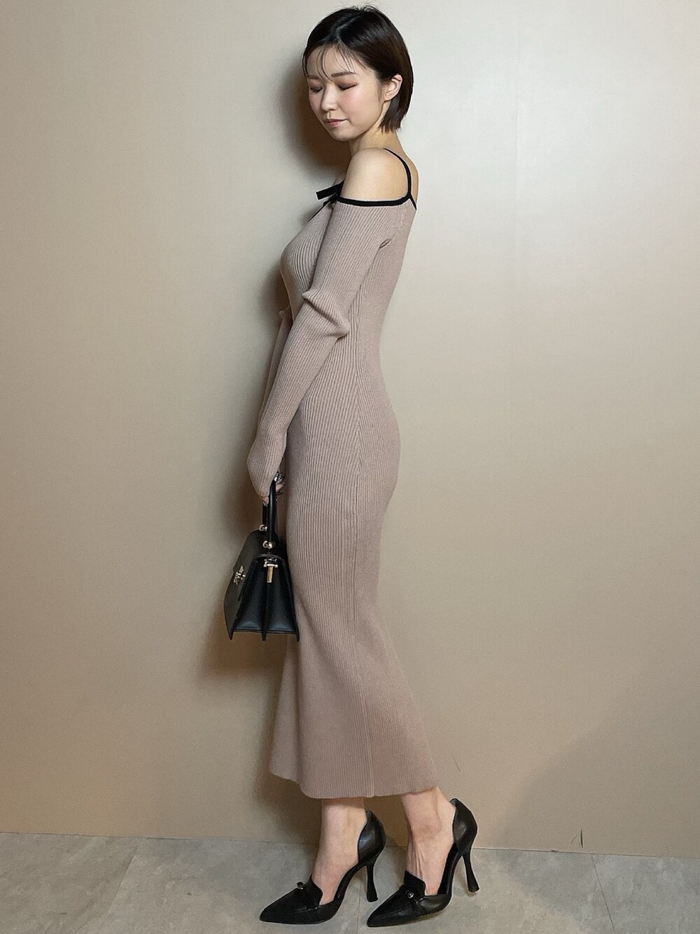 その他のワンピース、ブラック系のハンドバッグ、ブラック系のパンプスを着用したレディースの冬コーディネートの3枚目の写真