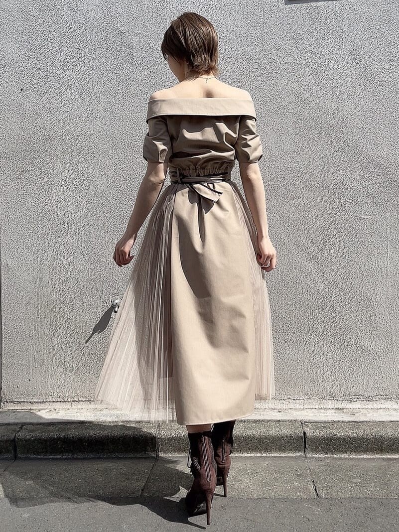 ベージュ系のワンピース、ブラウン系のブーツ、ゴールド系のネックレスを着用したレディースの春コーディネートの3枚目の写真