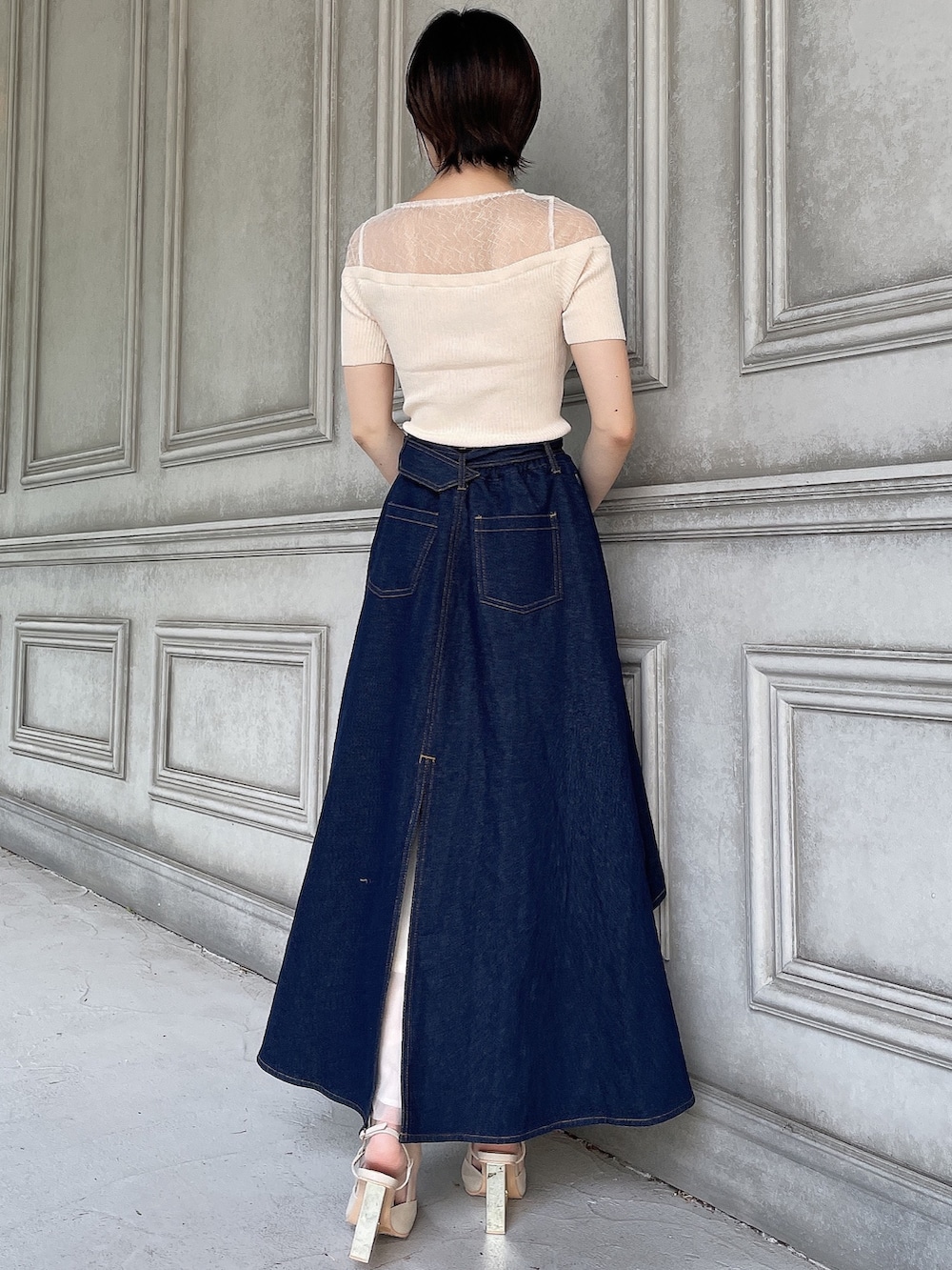 ブルー系のスカート、ホワイト系のニット/セーター、ベージュ系のサンダルを着用したレディースの夏コーディネートの4枚目の写真