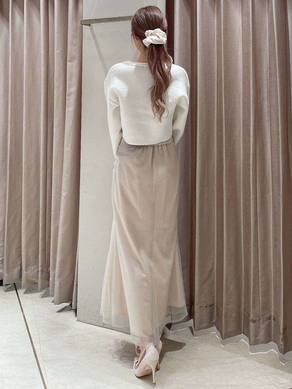 ホワイト系のカーディガン/ボレロ、ホワイト系のスカート、ホワイト系のパンプスを着用したレディースの秋コーディネートの4枚目の写真