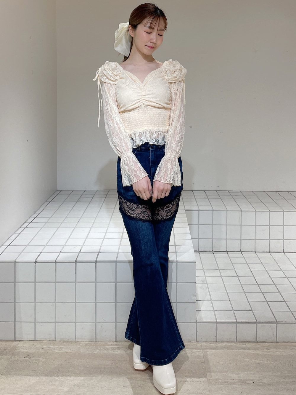 オレンジ系のシャツ/ブラウス、ブルー系のデニムパンツ、ホワイト系のブーツを着用したレディースの春コーディネートの2枚目の写真