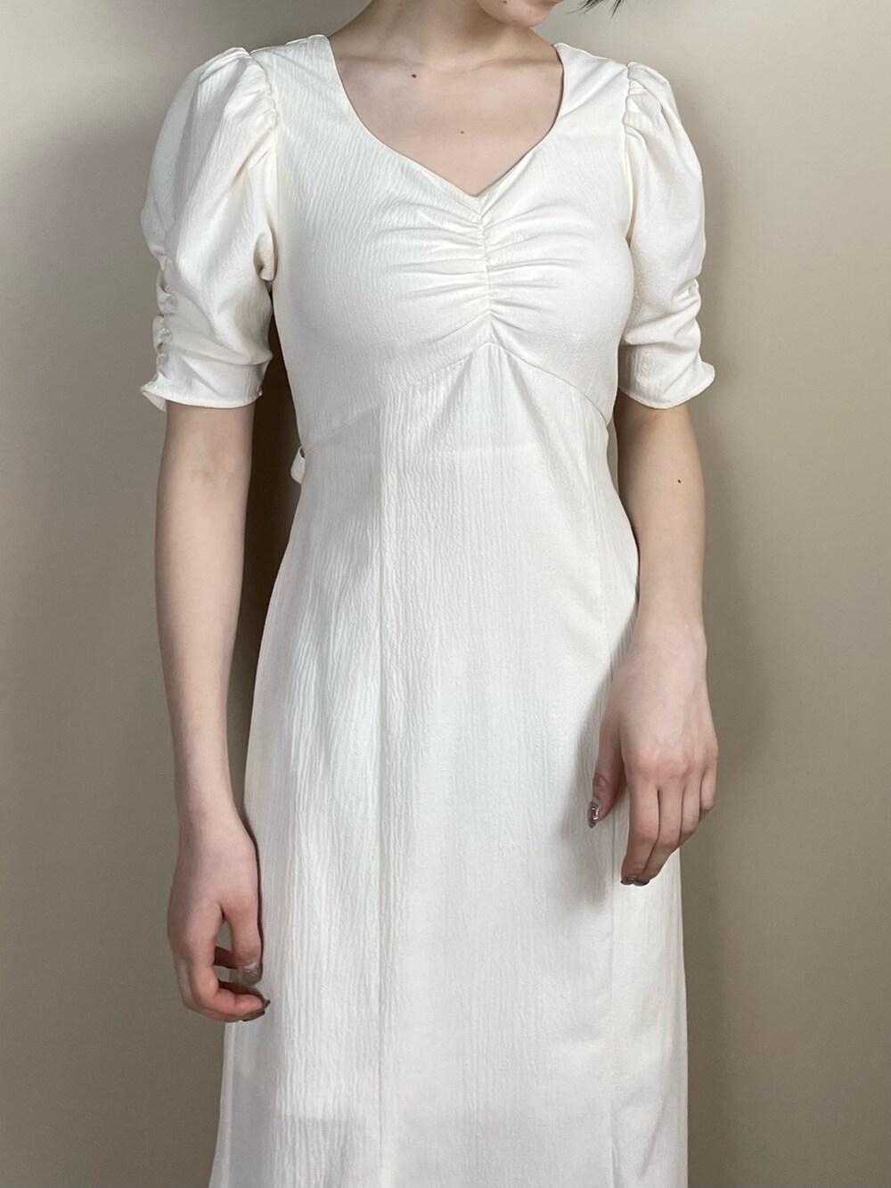 ホワイト系のサンダル、ホワイト系のワンピースを着用したレディースの春コーディネートの3枚目の写真