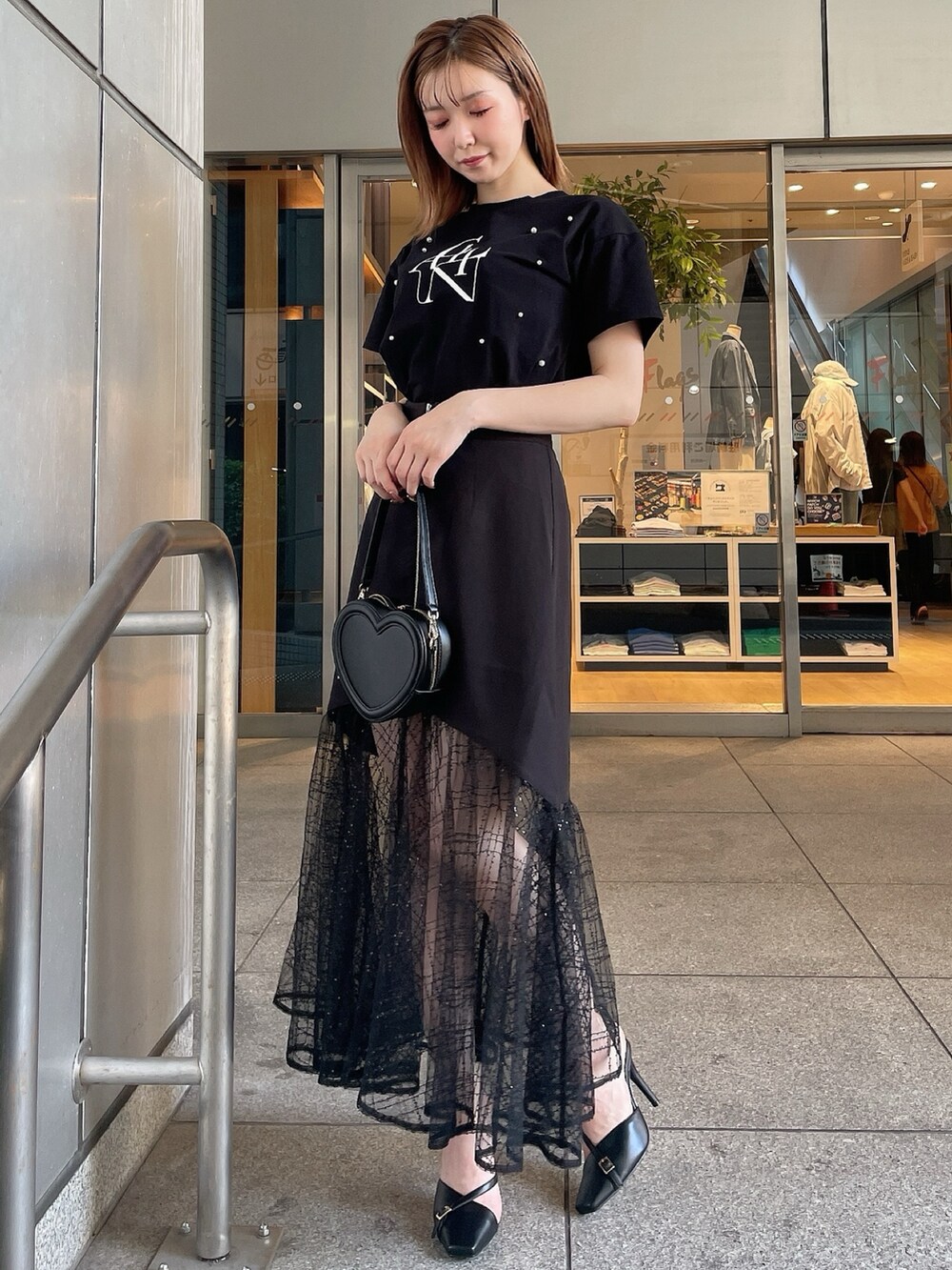 ブラック系のスリッポン、ブラック系のTシャツ/カットソー、ブラック系のスカートを着用したレディースの夏コーディネートの2枚目の写真