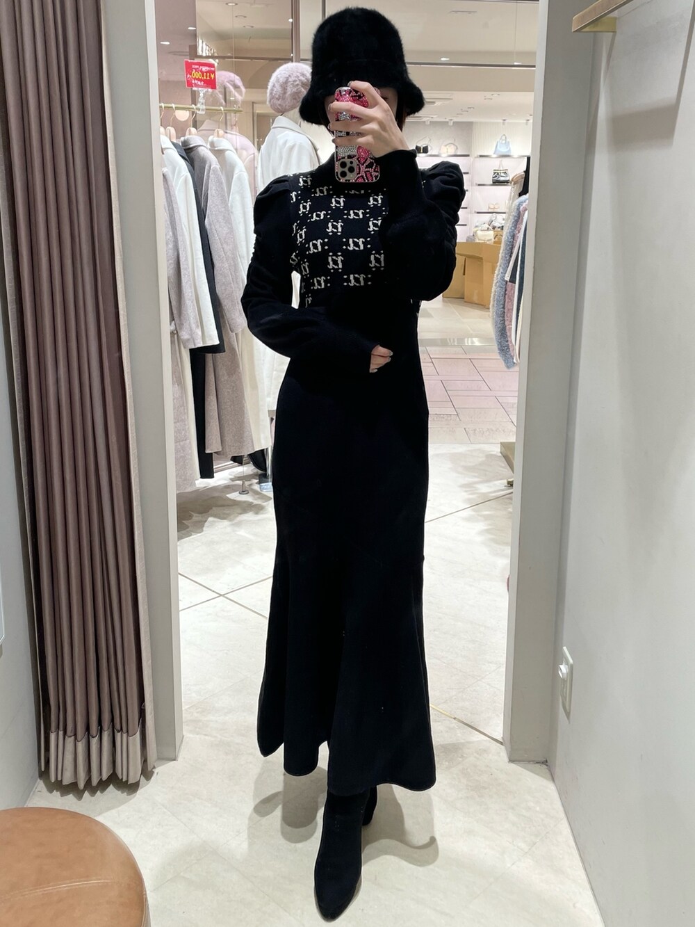 ブラック系のワンピース、ブラック系のブーツを着用したレディースの冬コーディネートの2枚目の写真