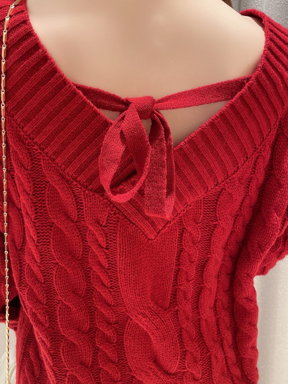 レッド系のニット/セーター、ホワイト系のスカート、ホワイト系のショルダーバッグを着用したレディースの冬コーディネートの7枚目の写真