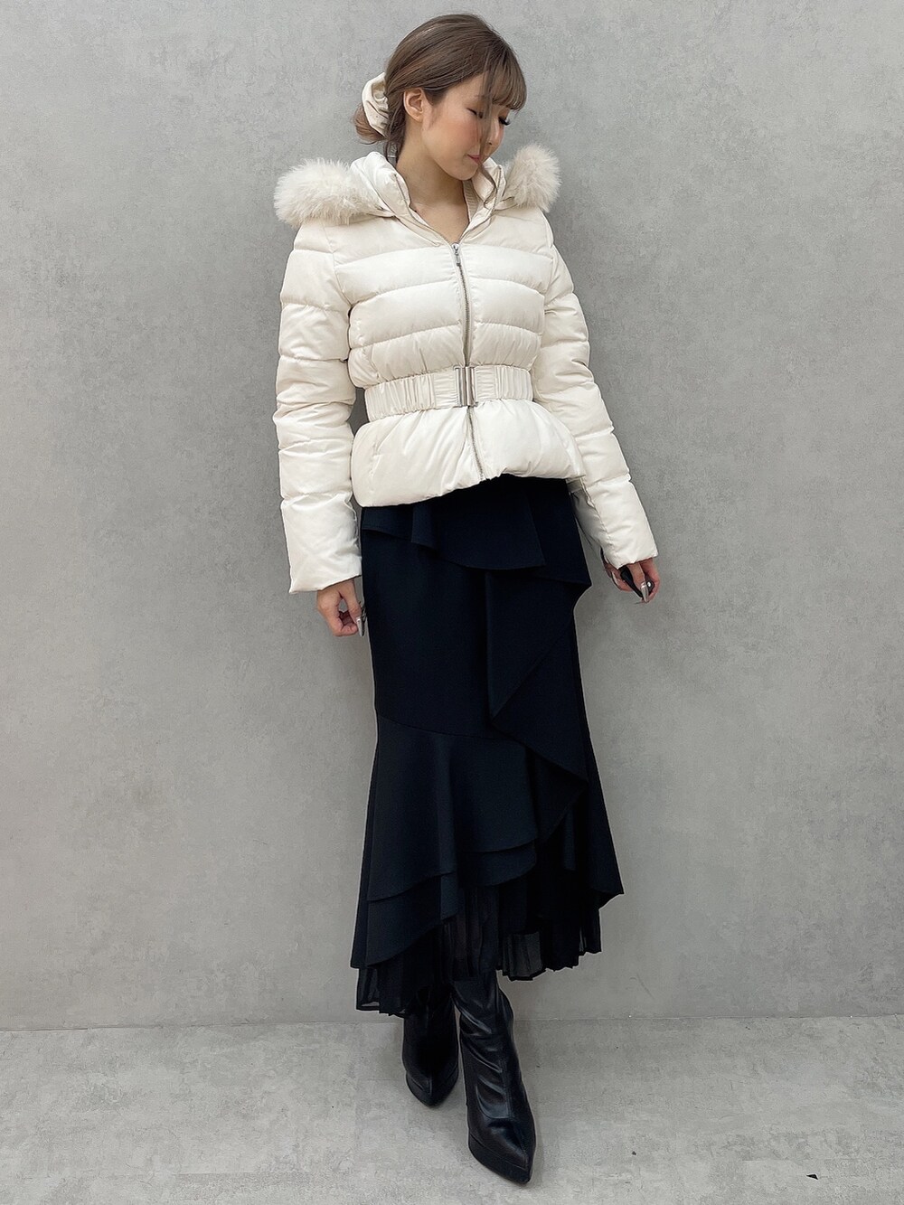 ホワイト系のダウンジャケット/コート、ホワイト系のニット/セーター、ブラック系のスカートを着用したレディースの秋コーディネートの4枚目の写真