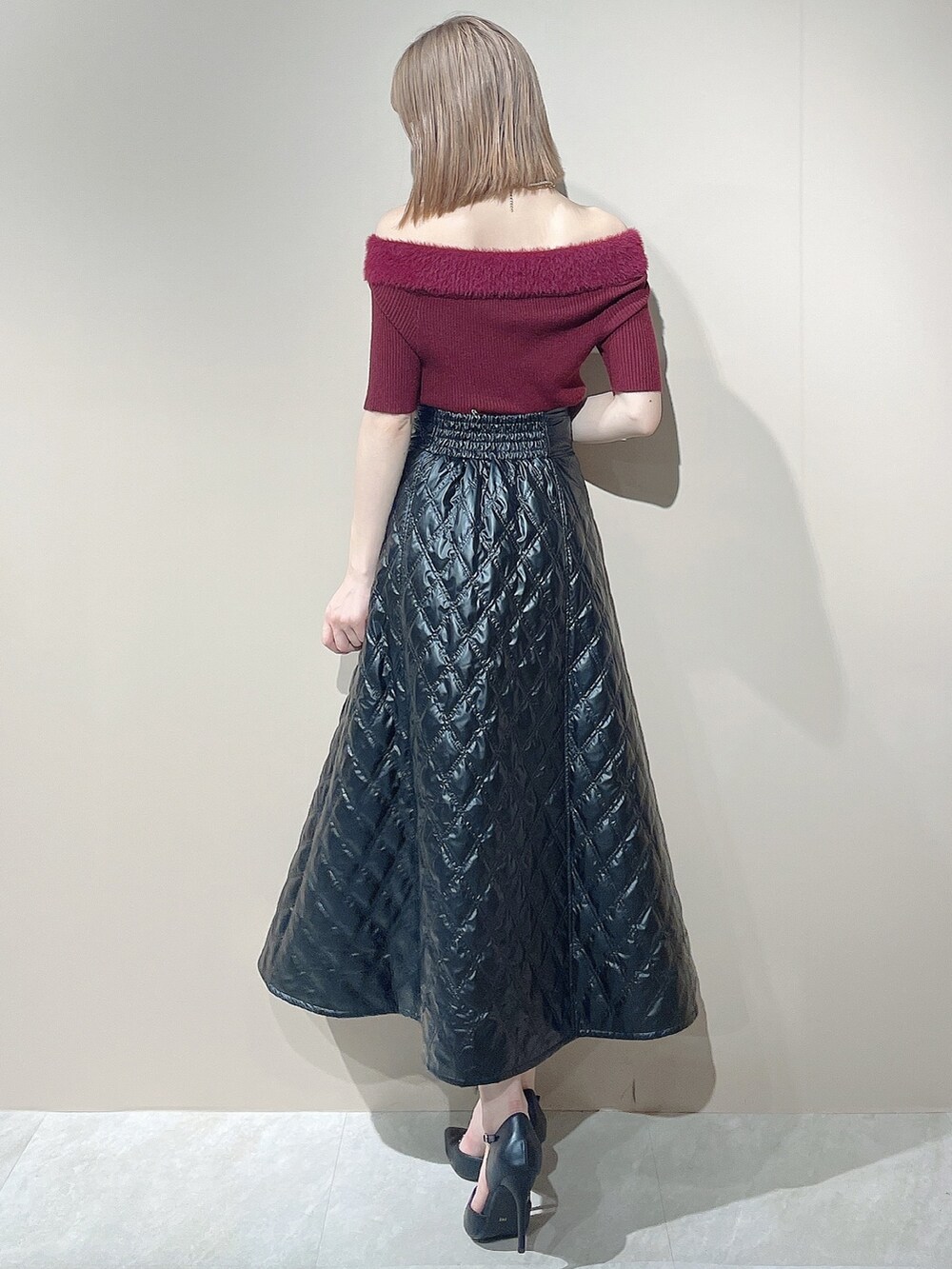 ブラック系のパンプス、レッド系のニット/セーター、ブラック系のスカートを着用したレディースの夏コーディネートの6枚目の写真