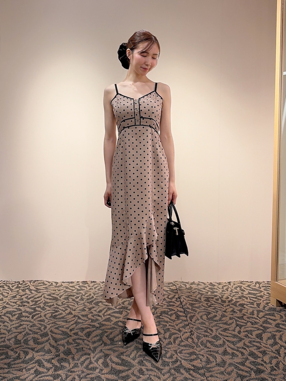 ベージュ系のワンピース、ブラック系のハンドバッグ、ブラック系のベストを着用したレディースの夏コーディネートの5枚目の写真
