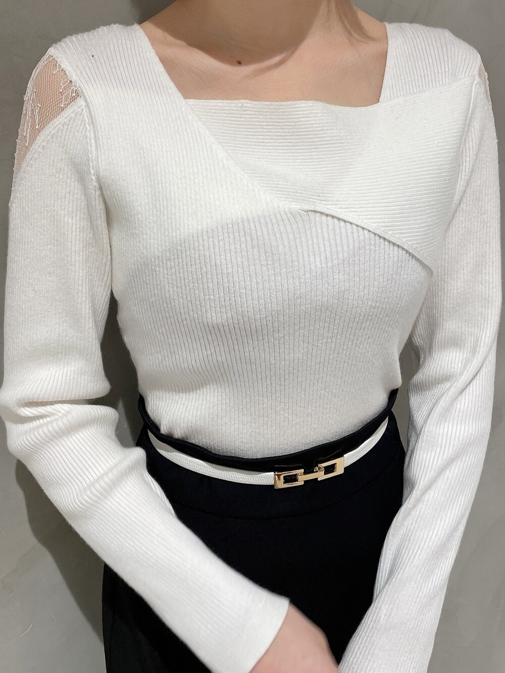 ホワイト系のニット/セーター、ベージュ系のハンドバッグ、ブラック系のスカートを着用したレディースの冬コーディネートの4枚目の写真