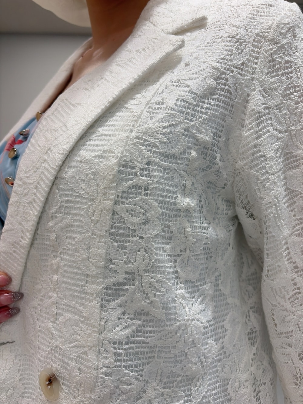 ホワイト系のテーラードジャケット、ブルー系のワンピース、ホワイト系のパンプスを着用したレディースの冬コーディネートの7枚目の写真