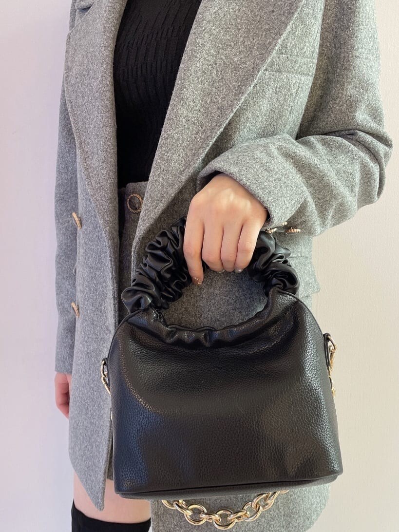 ブラック系のブーツ、グレー系のその他パンツ、ブラック系のハンドバッグを着用したレディースの秋コーディネートの9枚目の写真