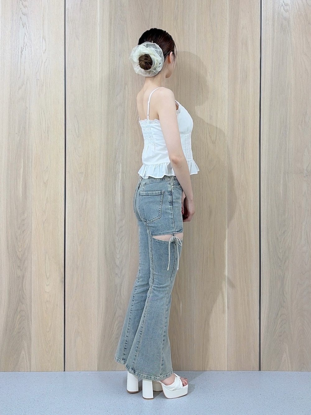 ホワイト系のキャミソール、ブルー系のデニムパンツ、ホワイト系のサンダルを着用したレディースの夏コーディネートの2枚目の写真