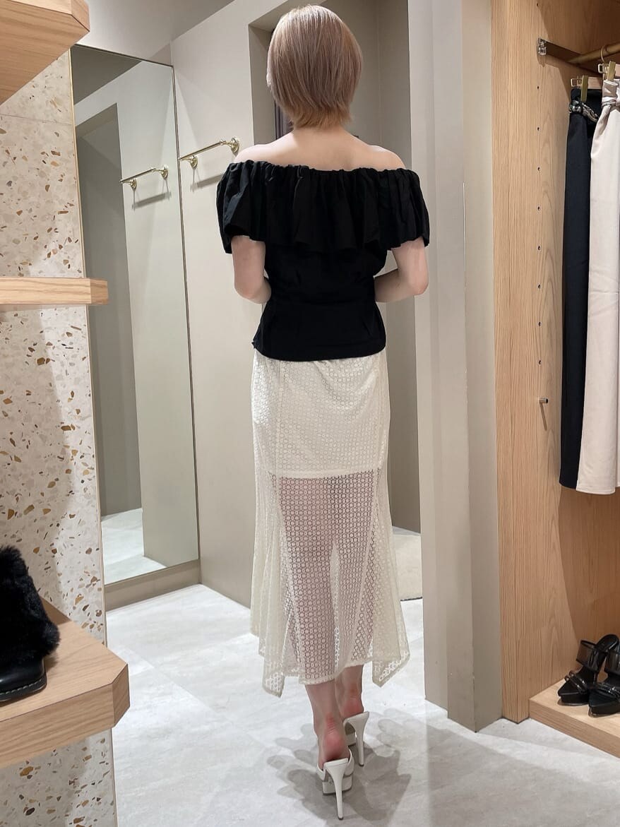 ホワイト系のスカート、ブラック系のシャツ/ブラウス、ホワイト系のサンダルを着用したレディースの夏コーディネートの3枚目の写真