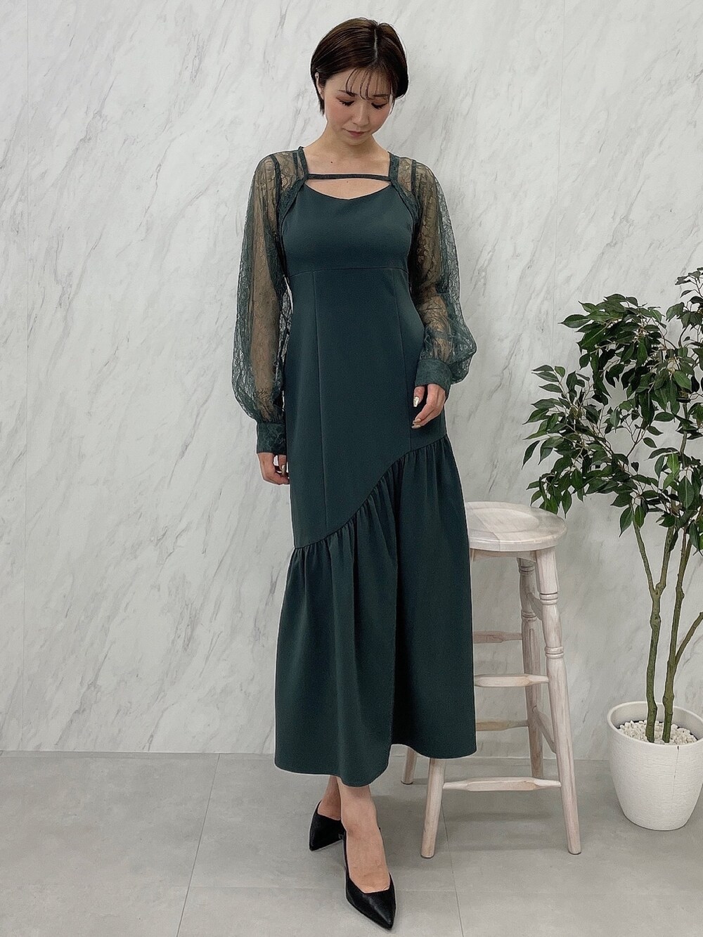 ブラック系のサンダル、グリーン系のワンピースを着用したレディースの秋コーディネートの2枚目の写真