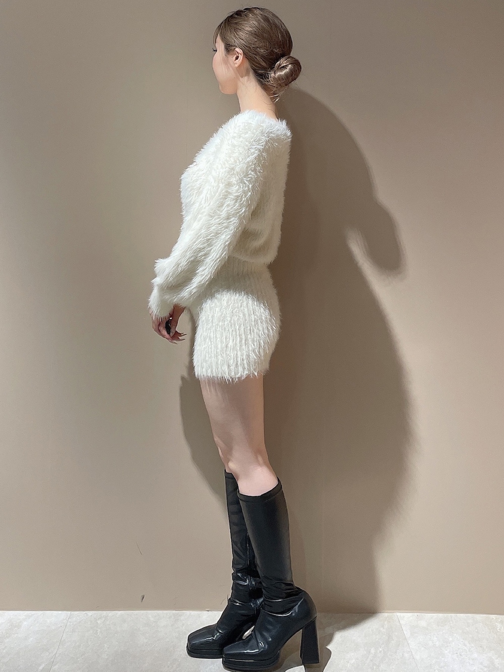 ホワイト系のワンピース、ブラック系のブーツを着用したレディースの秋コーディネートの4枚目の写真