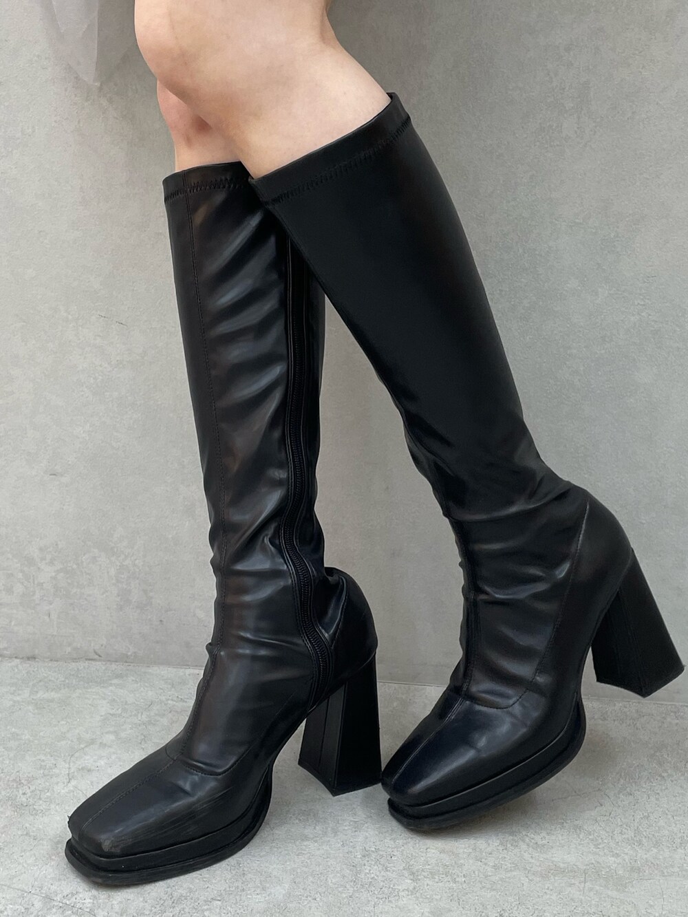 ホワイト系のニット/セーター、グレー系のスカート、ブラック系のブーツを着用したレディースの冬コーディネートの8枚目の写真