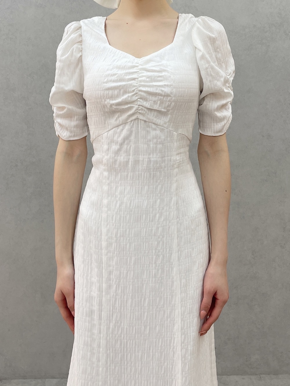 ホワイト系のワンピース、ホワイト系のサンダル、ホワイト系のバレッタ/ヘアクリップを着用したレディースの春コーディネートの4枚目の写真