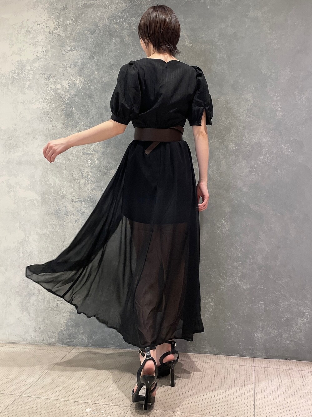 ブラック系のワンピース、ブラック系のサンダル、ブラウン系のベルトを着用したレディースの夏コーディネートの4枚目の写真